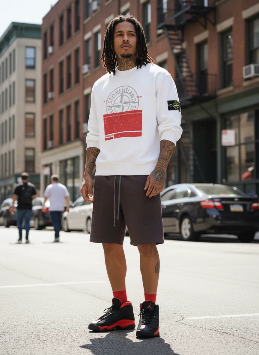 Stone Island Hoodie in White with Red and Grey Graphic, Fear of God Essentials Dark Brown Sweatshorts, Air Jordan 13 Retro Bred Sneakers